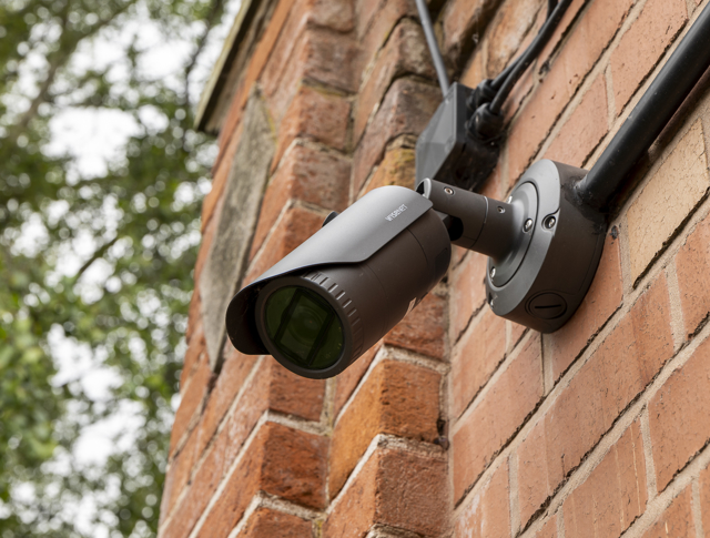 Close up shot of a black CCTV camera installed on an external wall