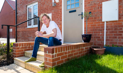 Man Sitting In Front Of His Home On The Steps