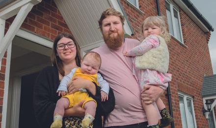 A family standing in front of their home (1)