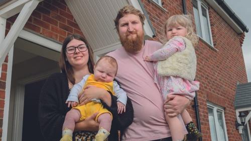 A family standing in front of their home (1)