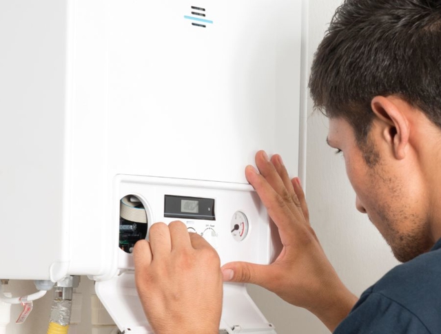 A person checking the boiler