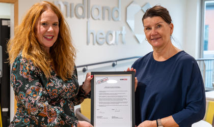 Two Women Holding A Framed Version Of The ASB Pledge