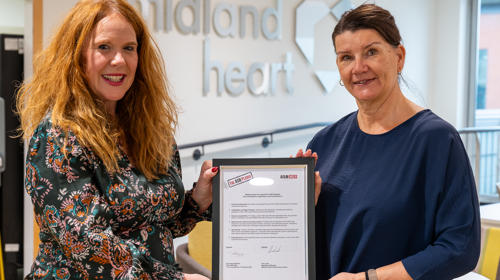 Two Women Holding A Framed Version Of The ASB Pledge