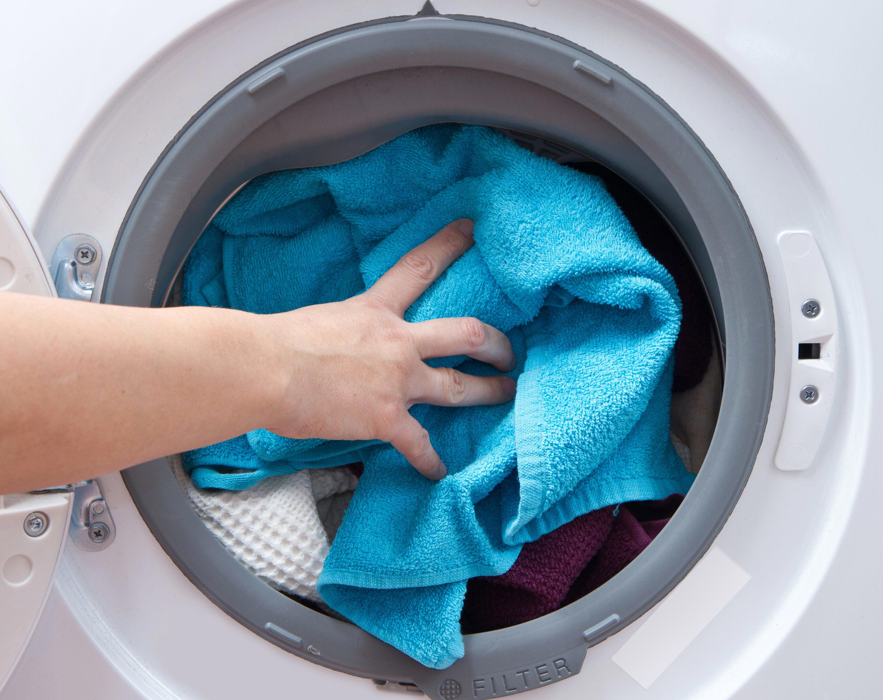 A person loading a washing machine