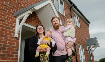 A family standing in front of their home
