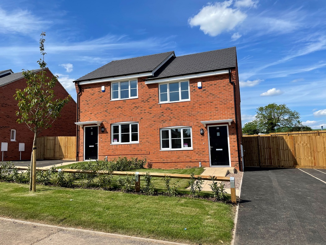 The front of 2 homes next to each other in the sunshine