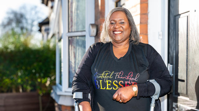 Tenant Standing In Her Front Garden Smiling In The Sunshine