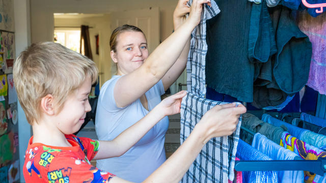 Tenant Hanging Clothing And Towels Up To Dry With Her Son