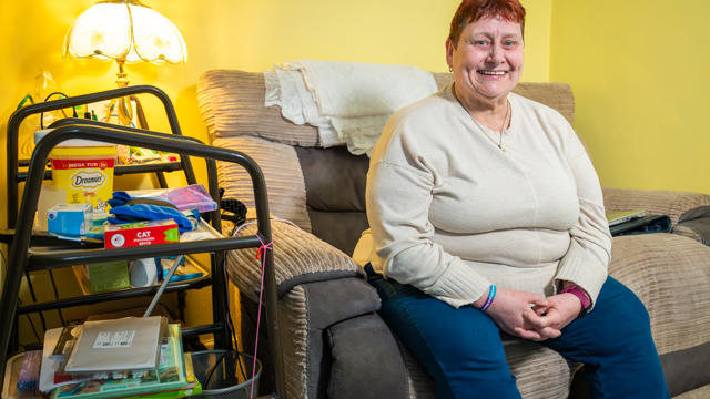 A Tenant Sitting On Her Sofa Smiling