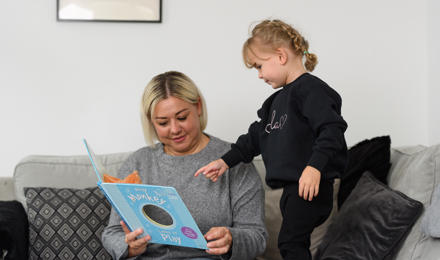 A mother reading a book with her daughter