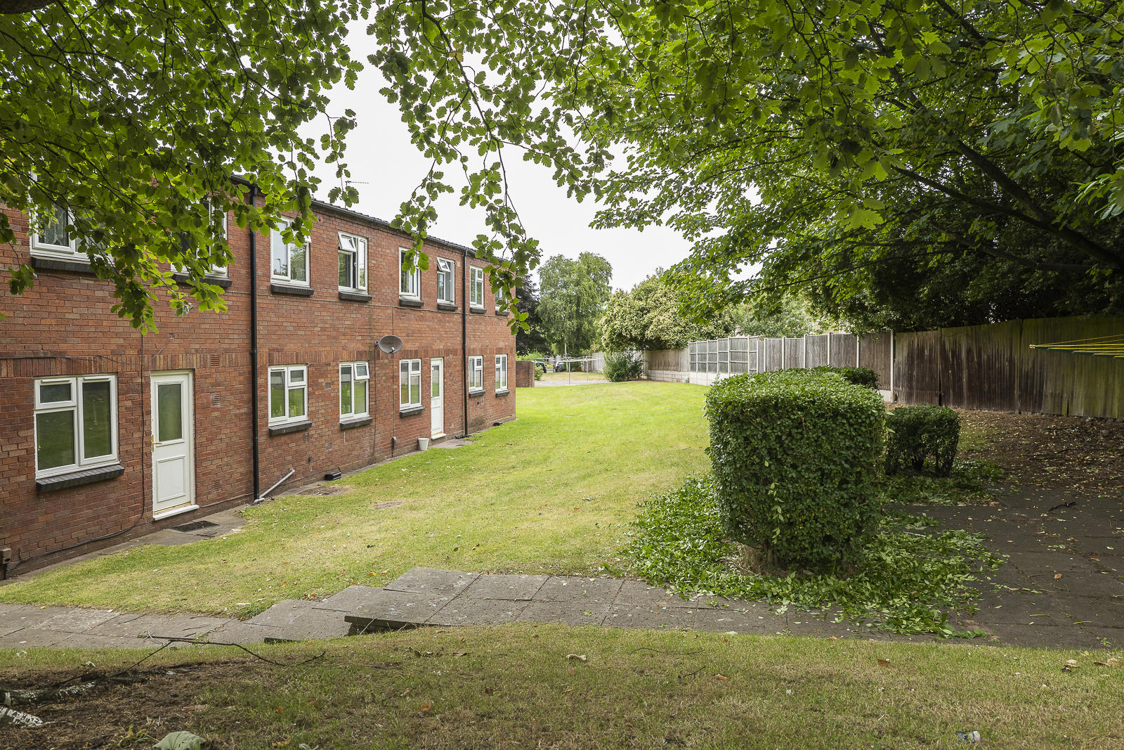 A row of homes on the left with fencing and greenery on the right A row of homes on the left with fencing and greenery on the right