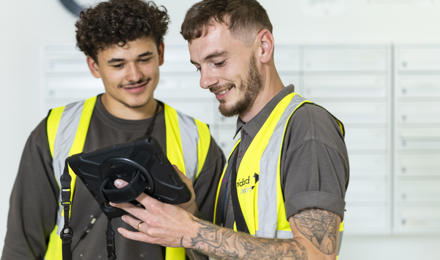 2 Midland Heart repairs operatives looking at a tablet