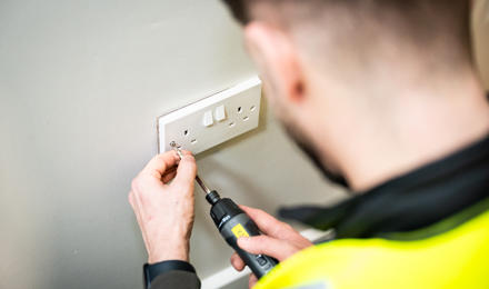 A Midland Heart Employee Fixing A Plug Socket