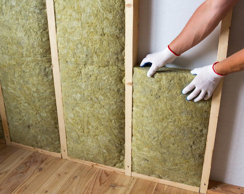 A person insulating a wall