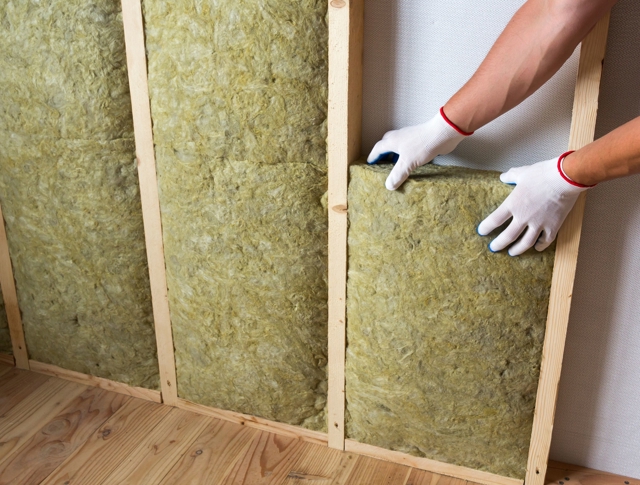 A person insulating a wall