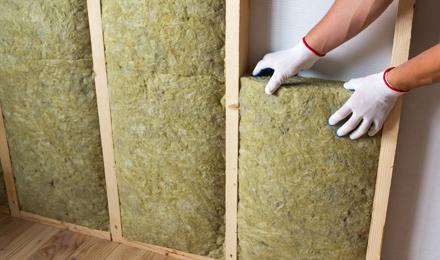 A person insulating a wall