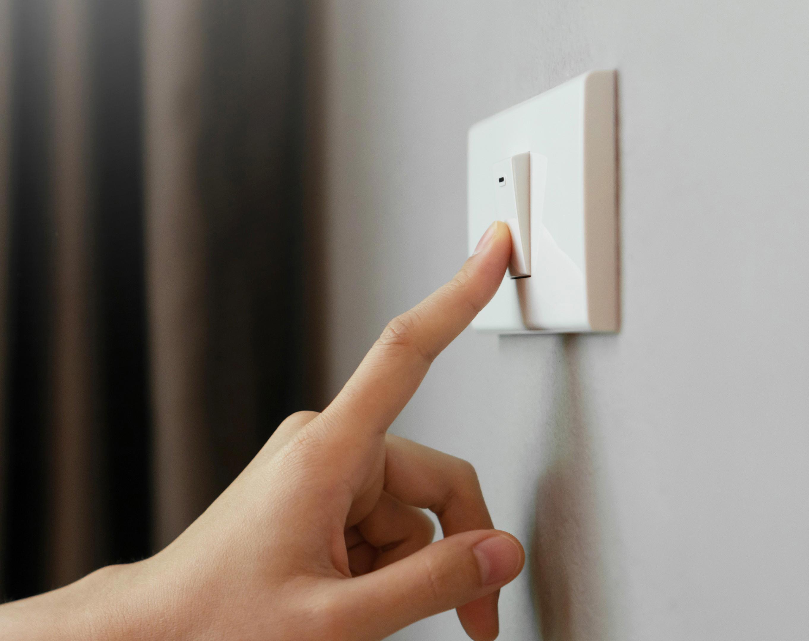 A person pressing a light switch