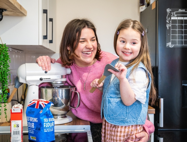 Mother In Kitchen With Daughter Getting Ready To Bake A Cake
