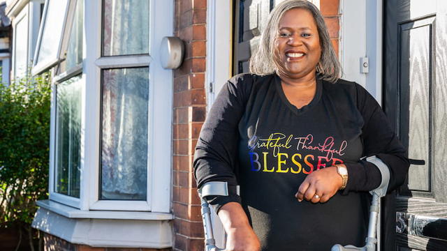 A Woman Standing Outside Her Home Smiling