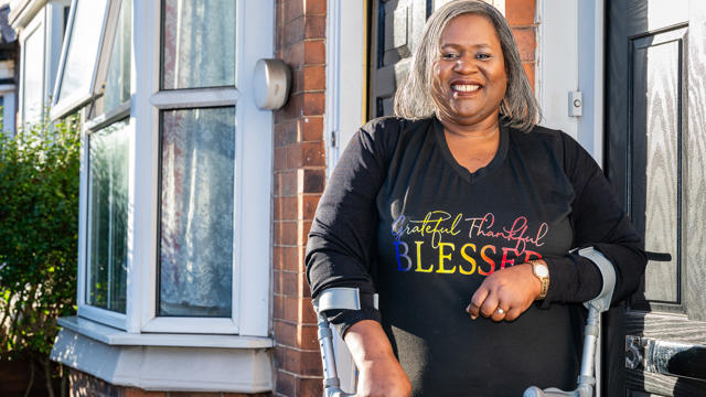 A Woman Standing Outside Her Home Smiling