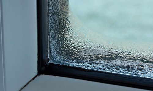 The corner of a window where condensation is forming