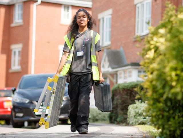 A repairs operative carrying a ladder and case