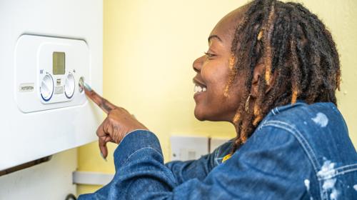Woman Wearing Blue Jacket Adjusting Boiler Controls
