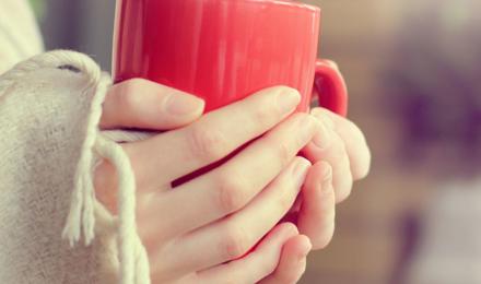 A person holding a warm mug with both hands