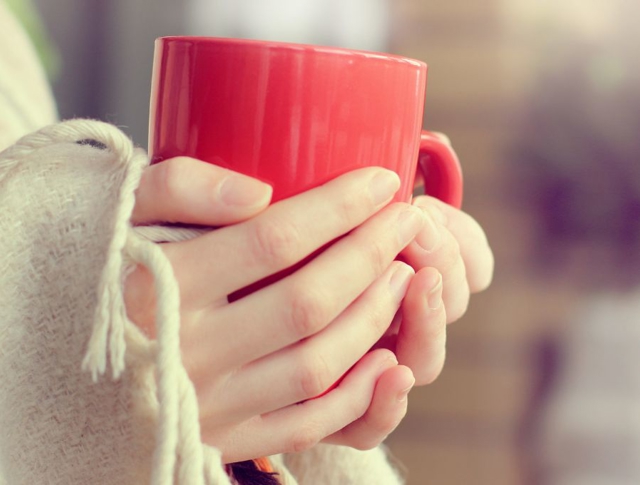 A person holding a warm mug with both hands