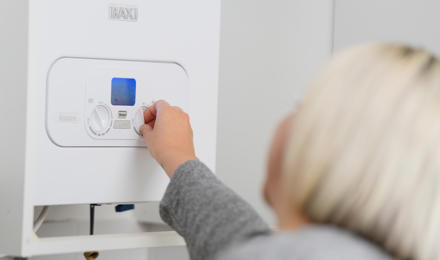 A tenant adjusting their boiler