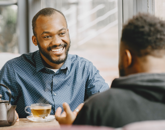 2 men sitting with each other at a table