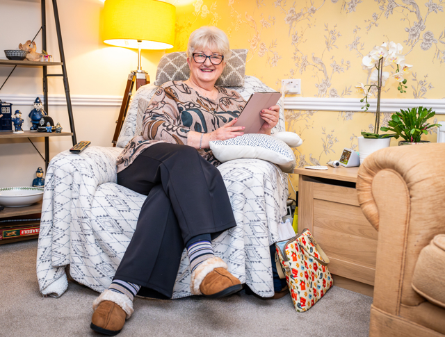 Woman Sitting In Her Armchair With A Tablet Computer