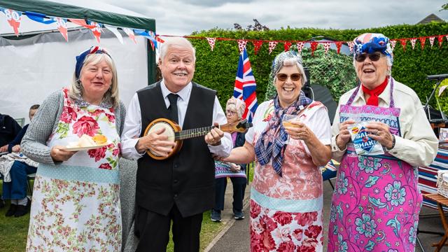 Residents Smiling For Camera With Items In Hand
