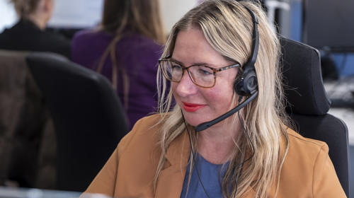 A Midland Heart employee with a headset looking at their computer