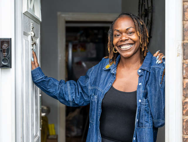 A Tenant Smiling And Opening Her Front Door