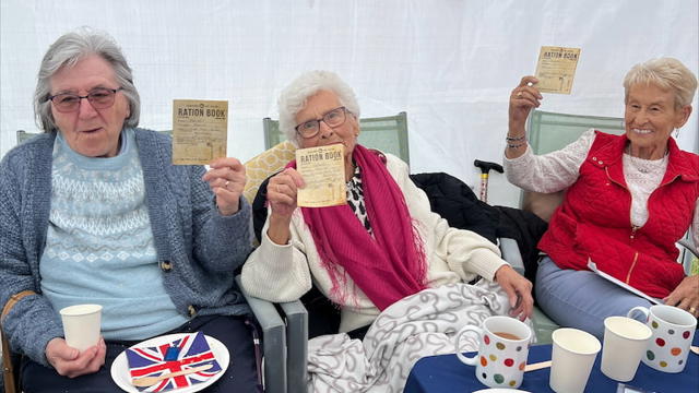 Residents Smiling And Holding Up Ration Cards