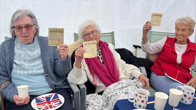 Residents Smiling And Holding Up Ration Cards